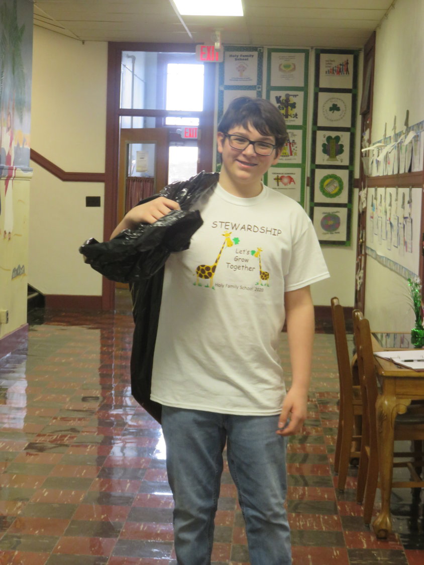 An eighth-grader at Holy Family School helps with the school's recycling project.